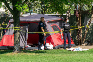 Police stand at an encampment